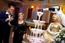 Ведущий юбилея Михаил Диденко и именинница в ресторане Венеция www.didenkom.ru - на фото праздничная пирамида шампанского